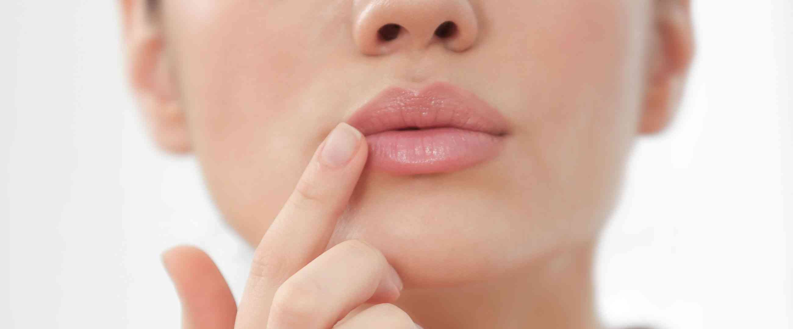 woman touching her lips after filler