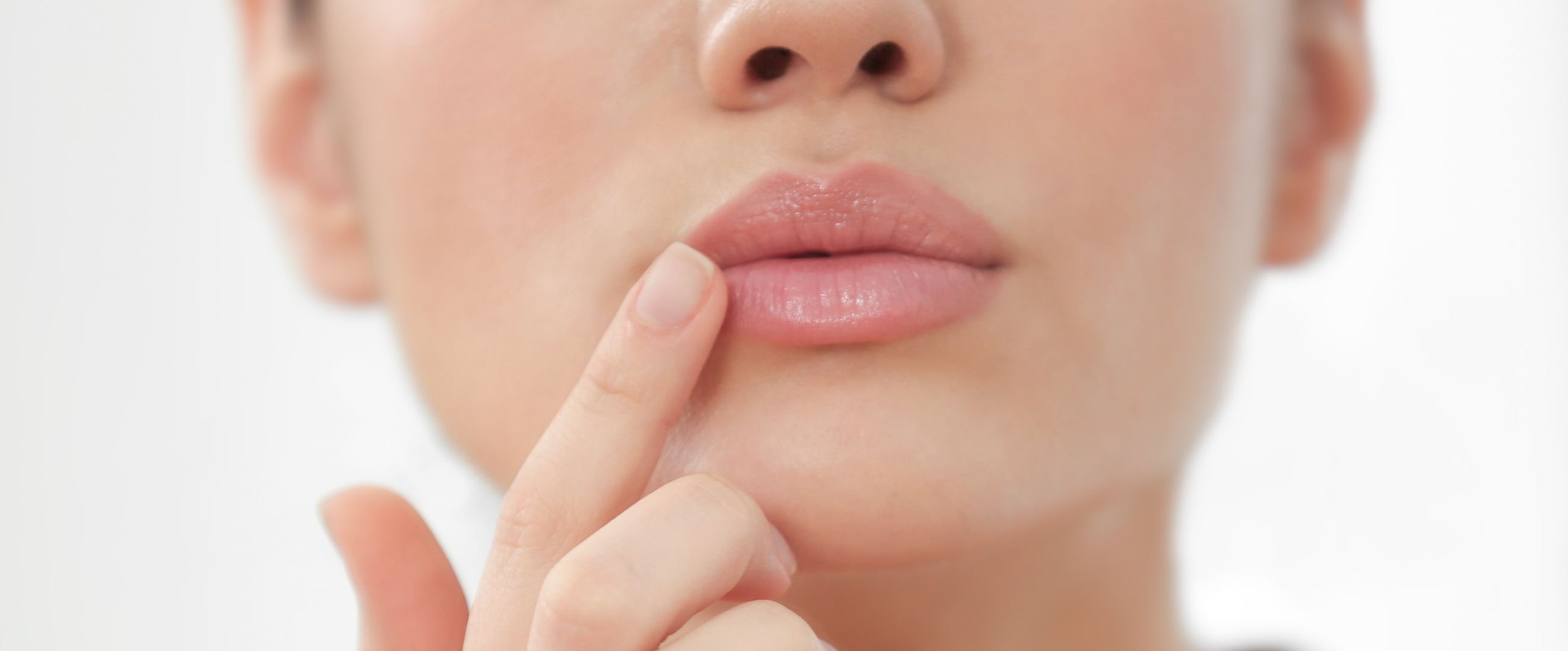 woman touching her lips after filler